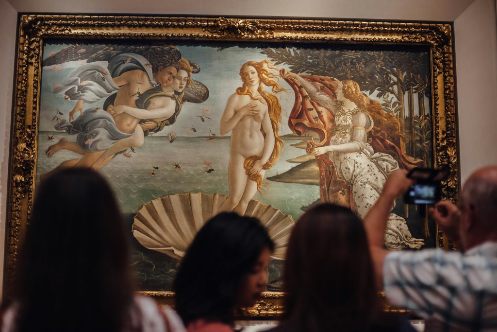 People in front of art at the Uffizi Gallery