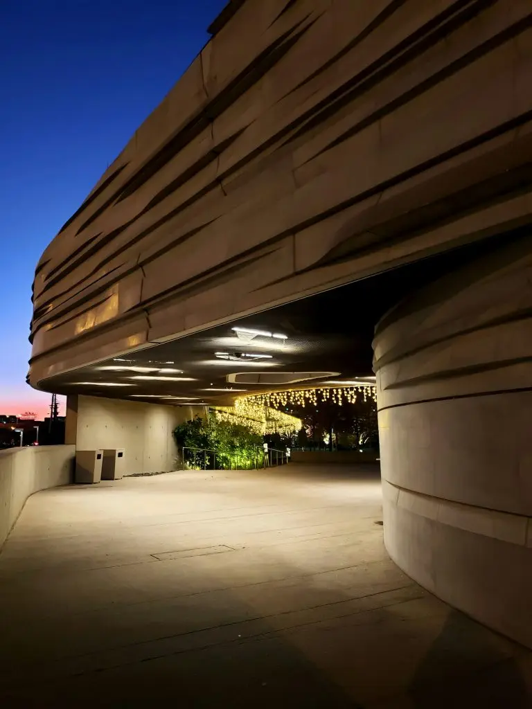 White concrete building with lights at night.