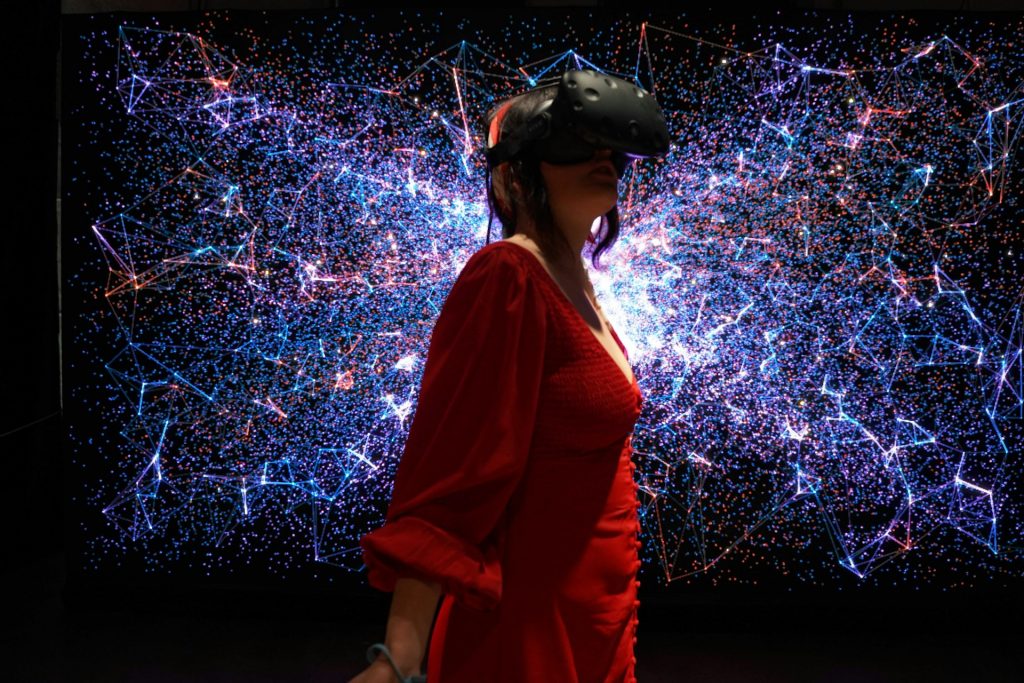 Women in a VR headset, in front of geometric illustration, symbolising art events in Atlanta