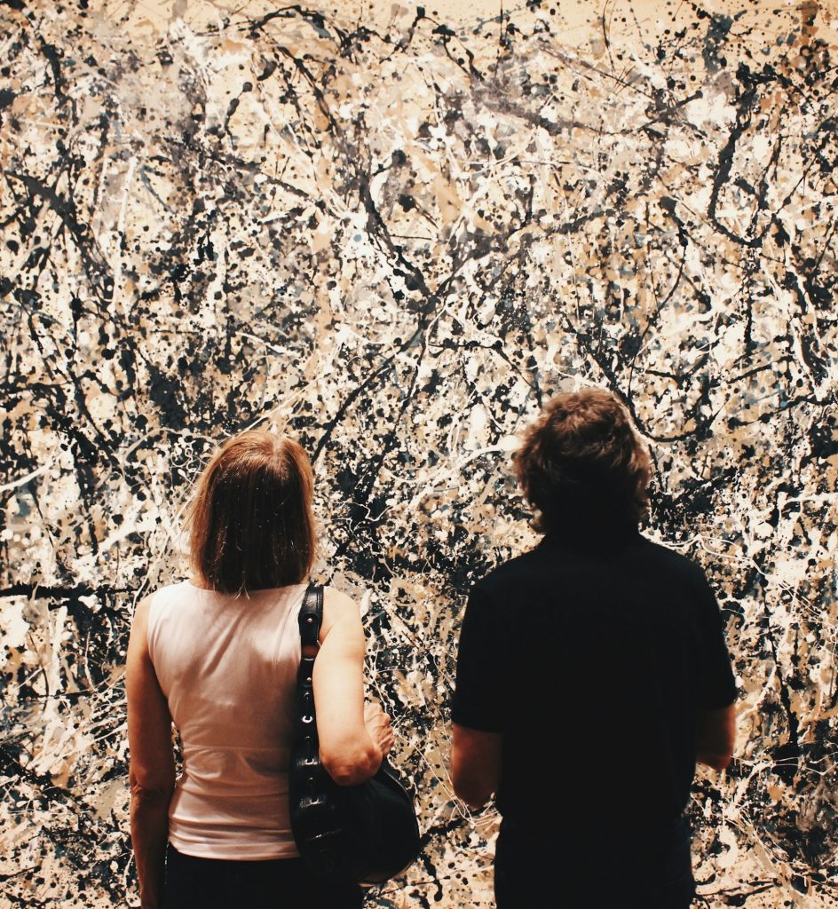 Two people standing in front of an abstract expressionist painting, like the ones seen at MOMA 2024