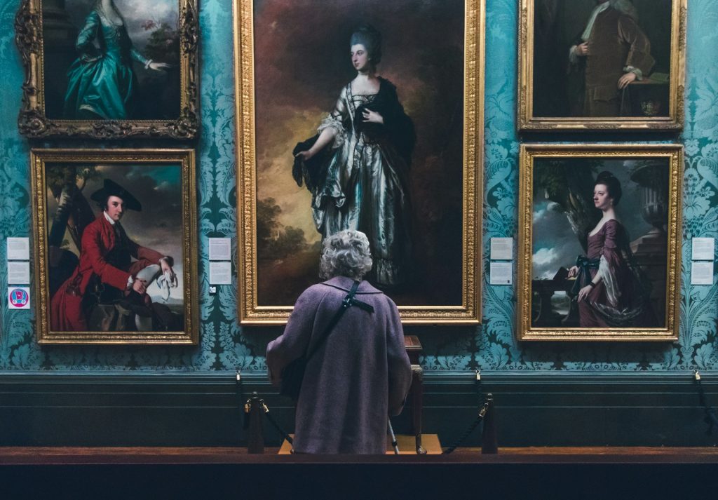 A person standing in front of paintings