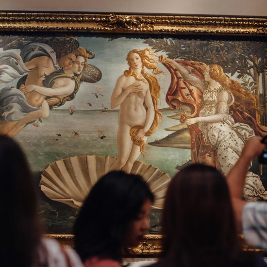 People in front of art at the Uffizi Gallery