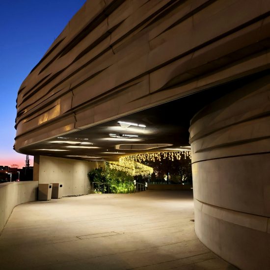 White concrete building with lights at night.