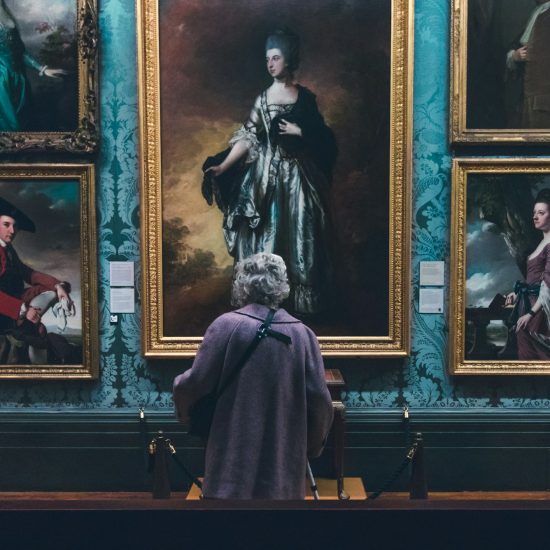 A person standing in front of paintings